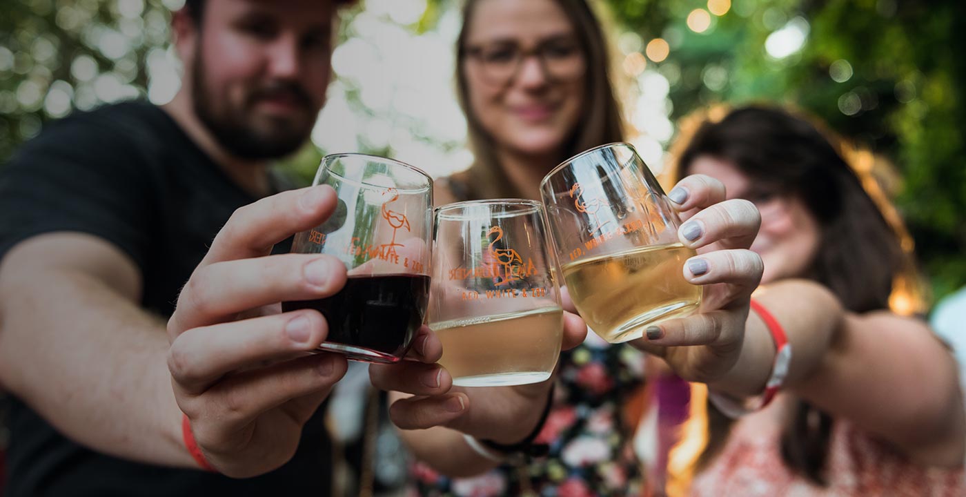 people holding out 3 wine glasses